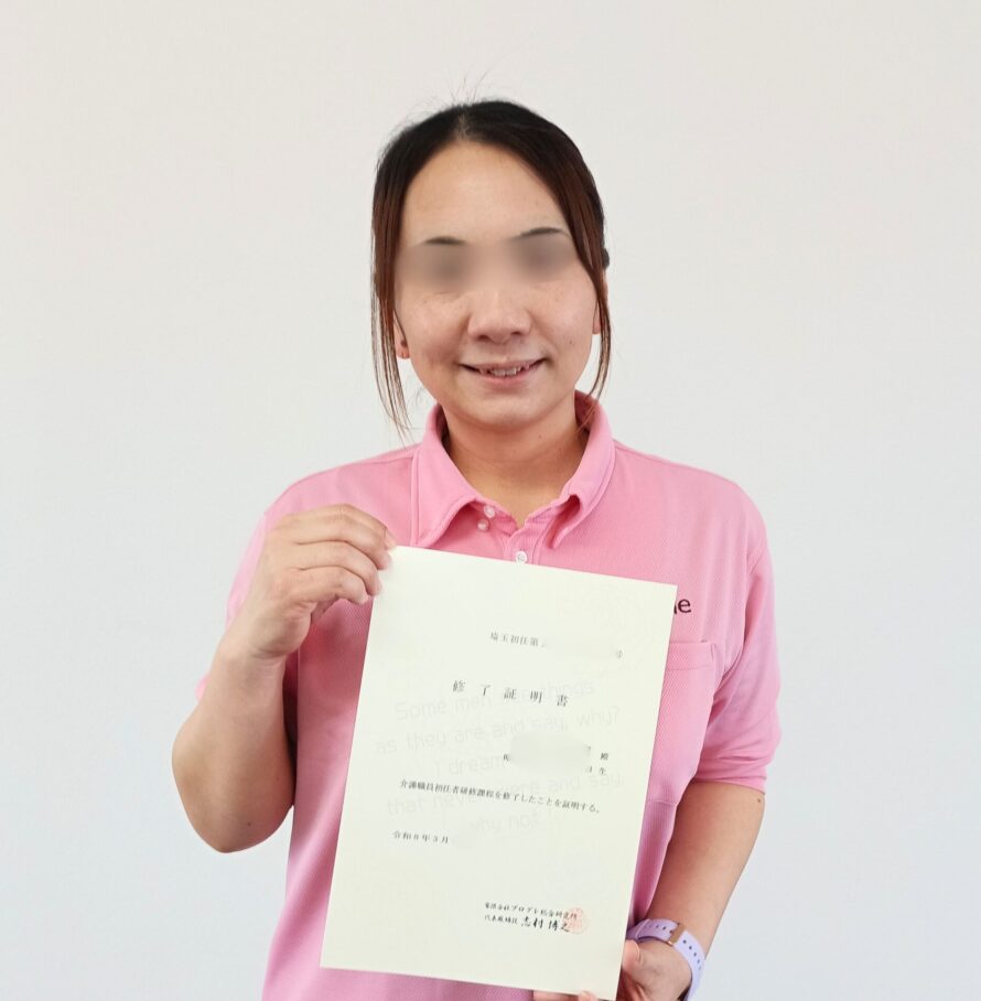 資格証を持つ笑顔のKさん